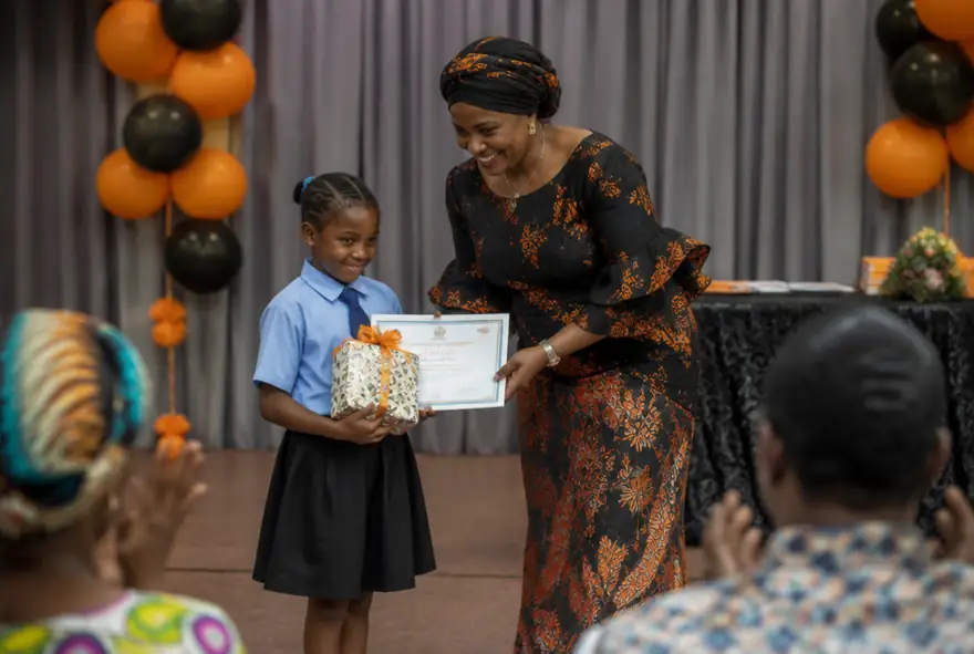 A pupil receiving a prize on stage at Speech and Prize Giving Day